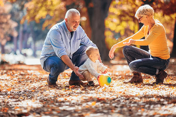 Grandparents and grandson together in autumn park