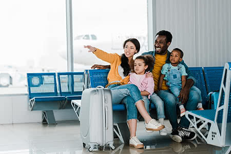 a family sits in an airport waiting for a flight